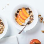 bowl of cereal with sliced fruits and spoon